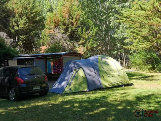 Carpa instalada junto al vehículo en sitio delimitado del camping